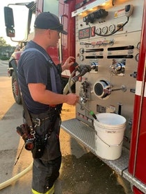 A firefighter is operating equipment on a fire truck.