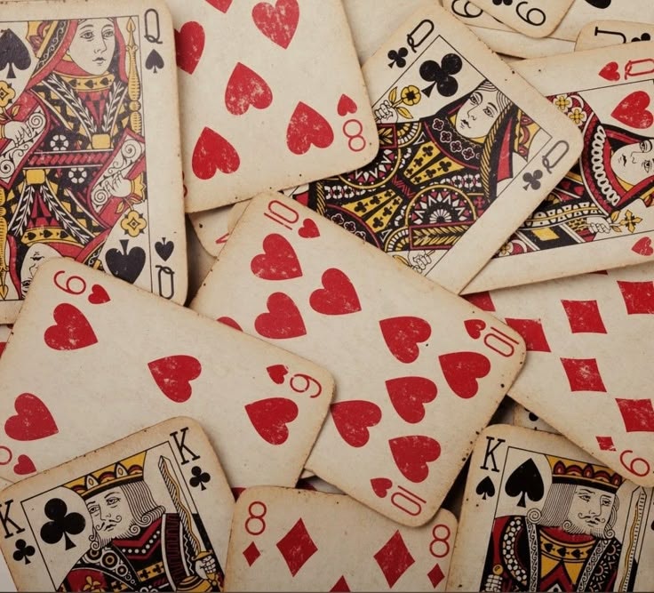 A scattered pile of playing cards, featuring various queens, kings, and numbers from the deck.