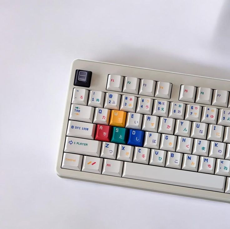 A retro-style keyboard with colorful keys and Japanese characters, featuring unique labels like "1 PLAYER" and "SFC 1998."