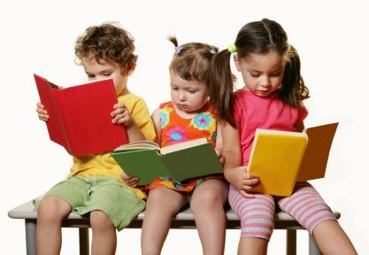 Three children sitting on a bench, each reading a different colored book.