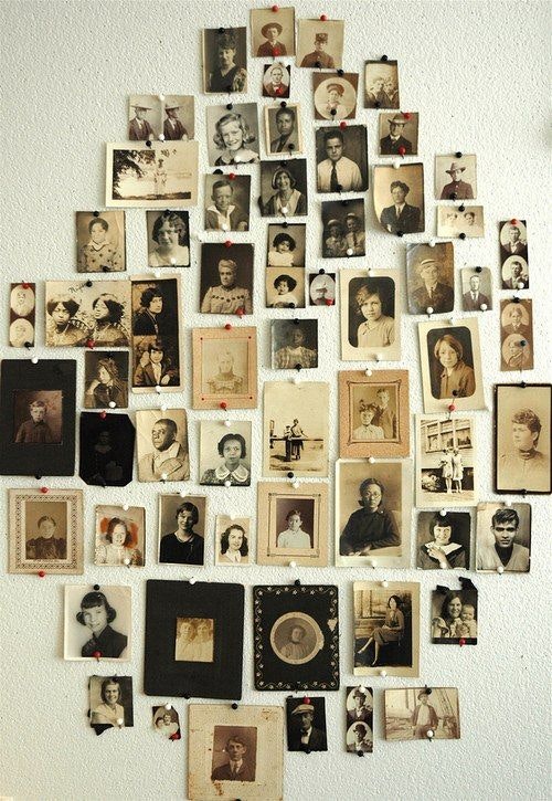 A collage of vintage black-and-white portraits arranged on a wall.