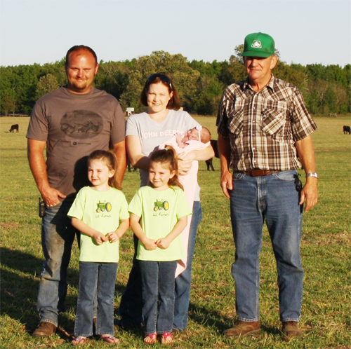 May contain: clothing, pants, t-shirt, people, person, face, head, photography, portrait, grass, plant, jeans, baseball cap, cap, hat, nature, outdoors, park, adult, male, man, shirt, footwear, shoe, animal, cattle, cow, livestock, and mammal