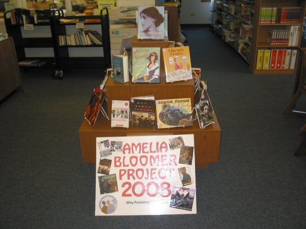 The image features a library display for the Amelia Bloomer Project 2008, showcasing feminist literature and related books.