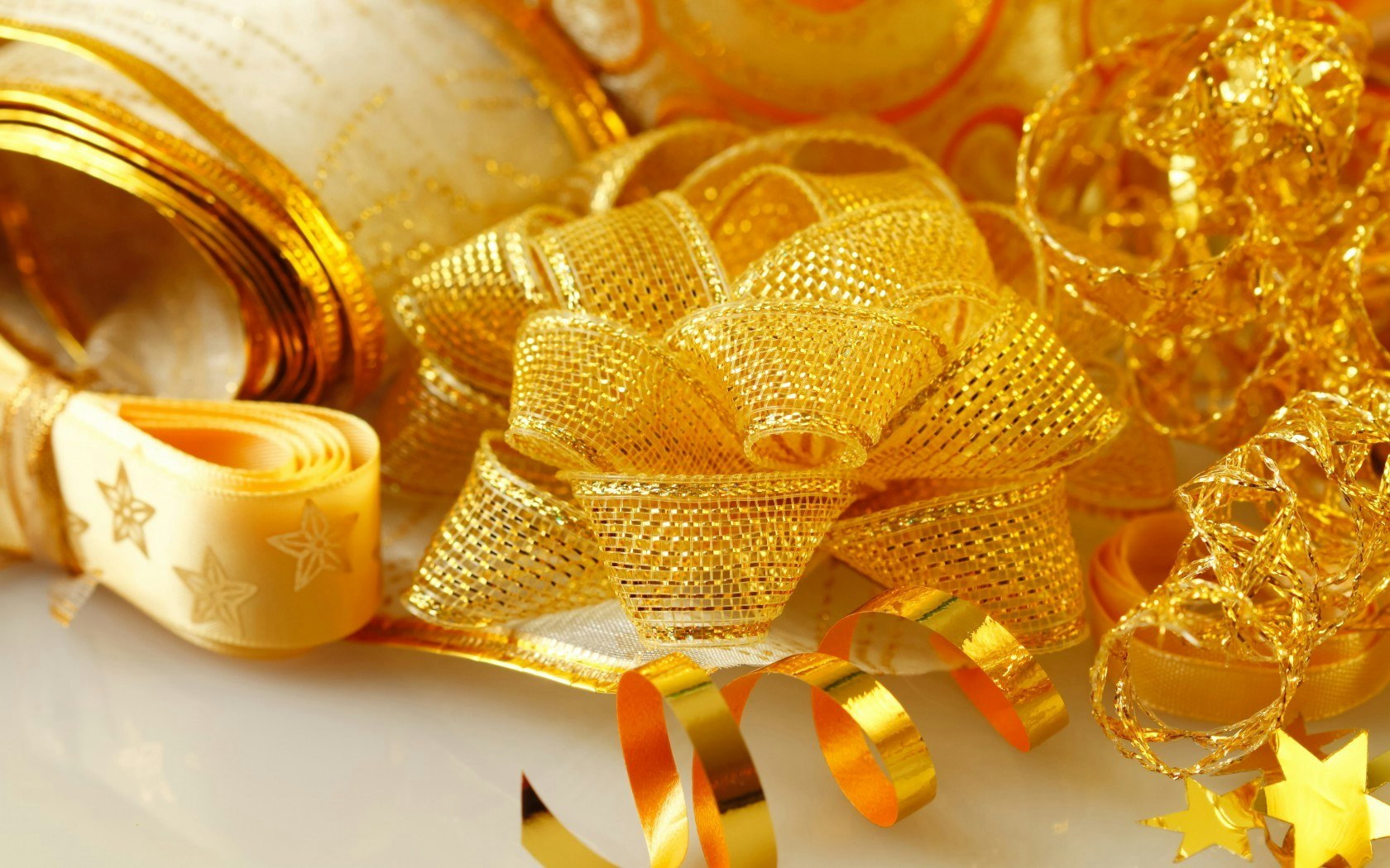 A collection of golden and yellow ribbons and bows, perfect for gift wrapping and decoration, creating a festive atmosphere.