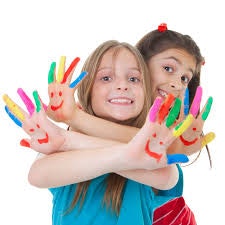 Two children smiling, showing hands painted with colorful designs and smiley faces.
