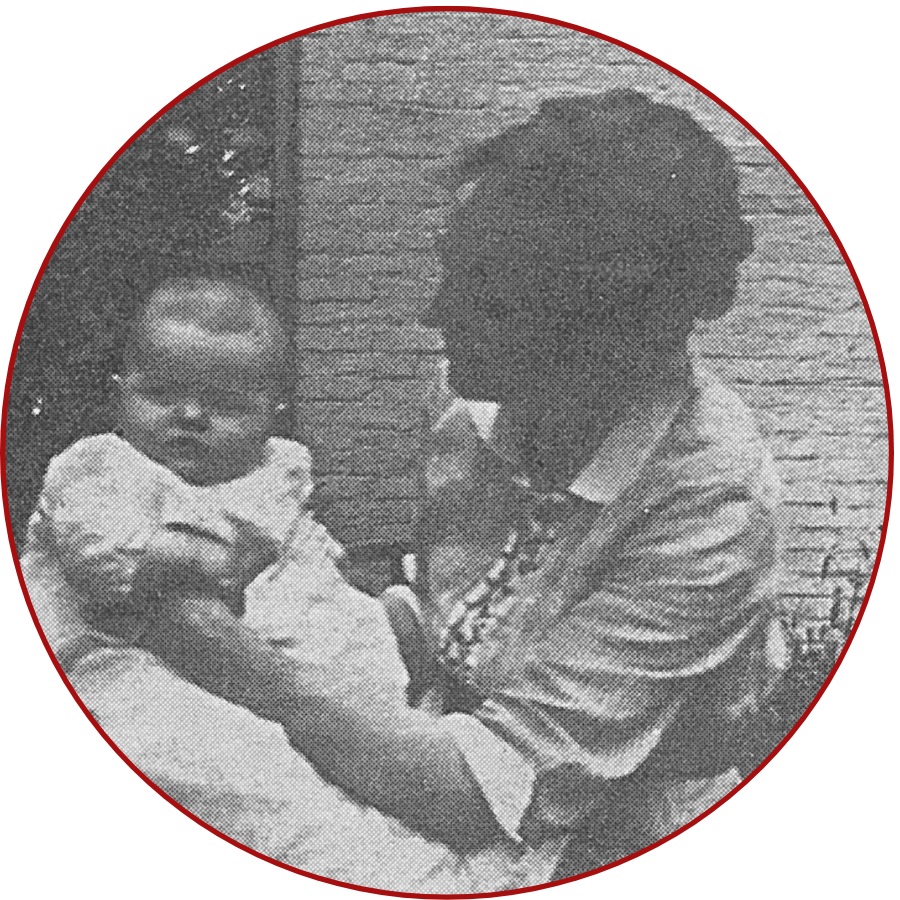 A woman holding a baby outdoors, in a vintage black and white photograph with a circular red border.