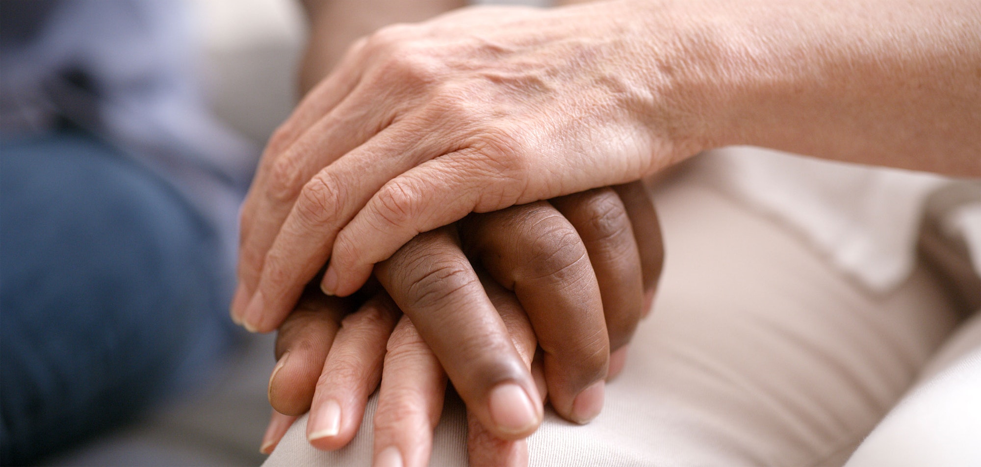 Two hands gently holding each other, conveying comfort and support.