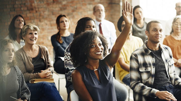 Woman with raised hand in a classroom