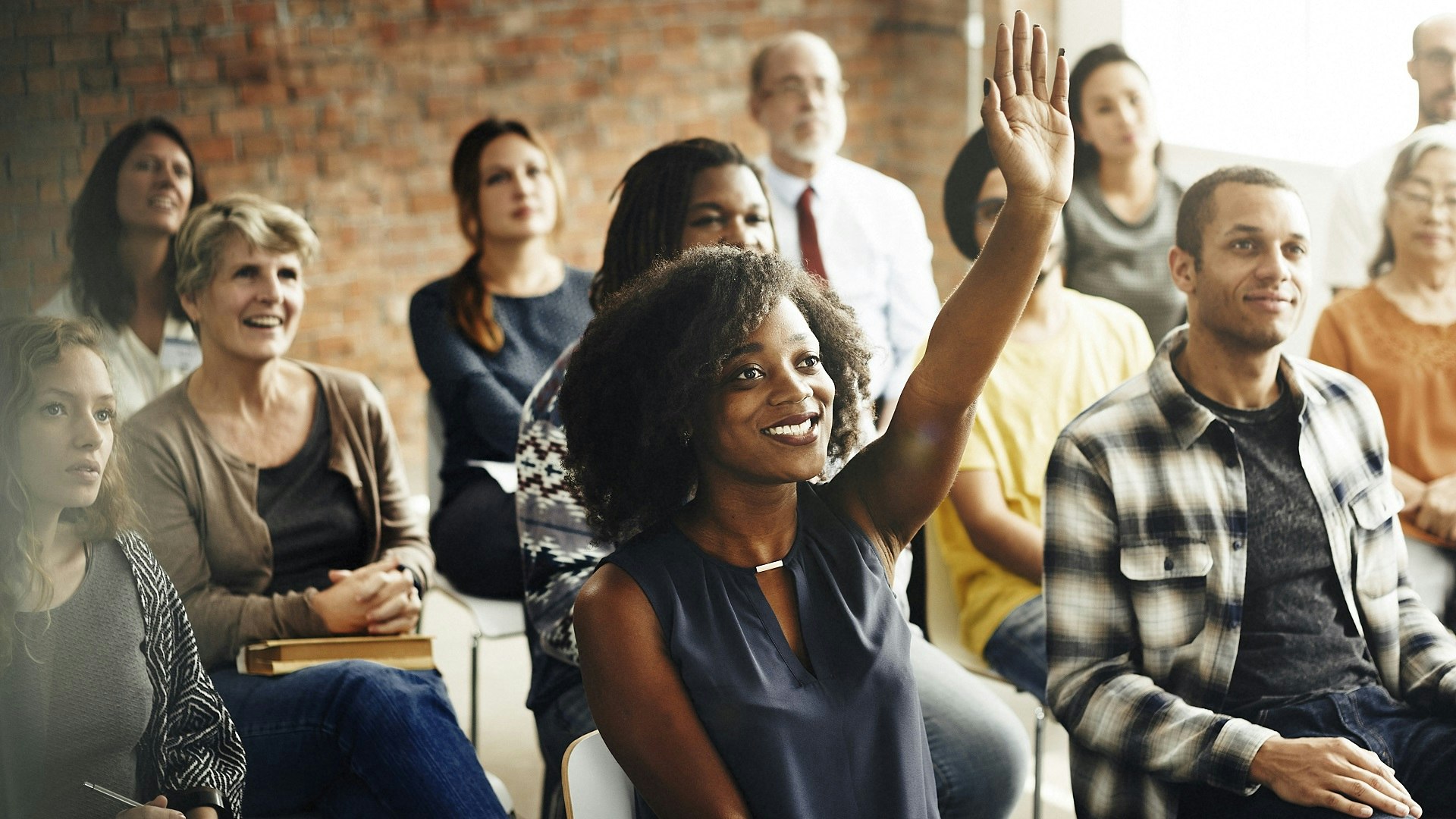Woman with raised hand in a classroom