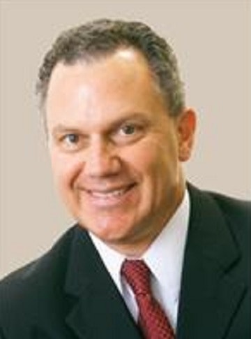 Jeff Kissiar in a suit with a red tie smiling.