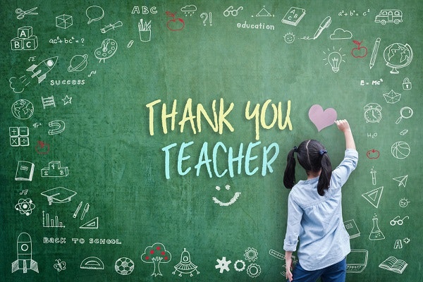 child writing "Thank you teacher" on a chalkboard