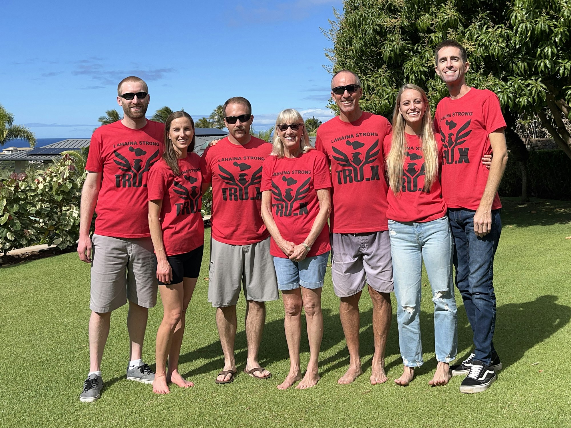 David Brown and six family members in matching red shirts, standing on a lawn.