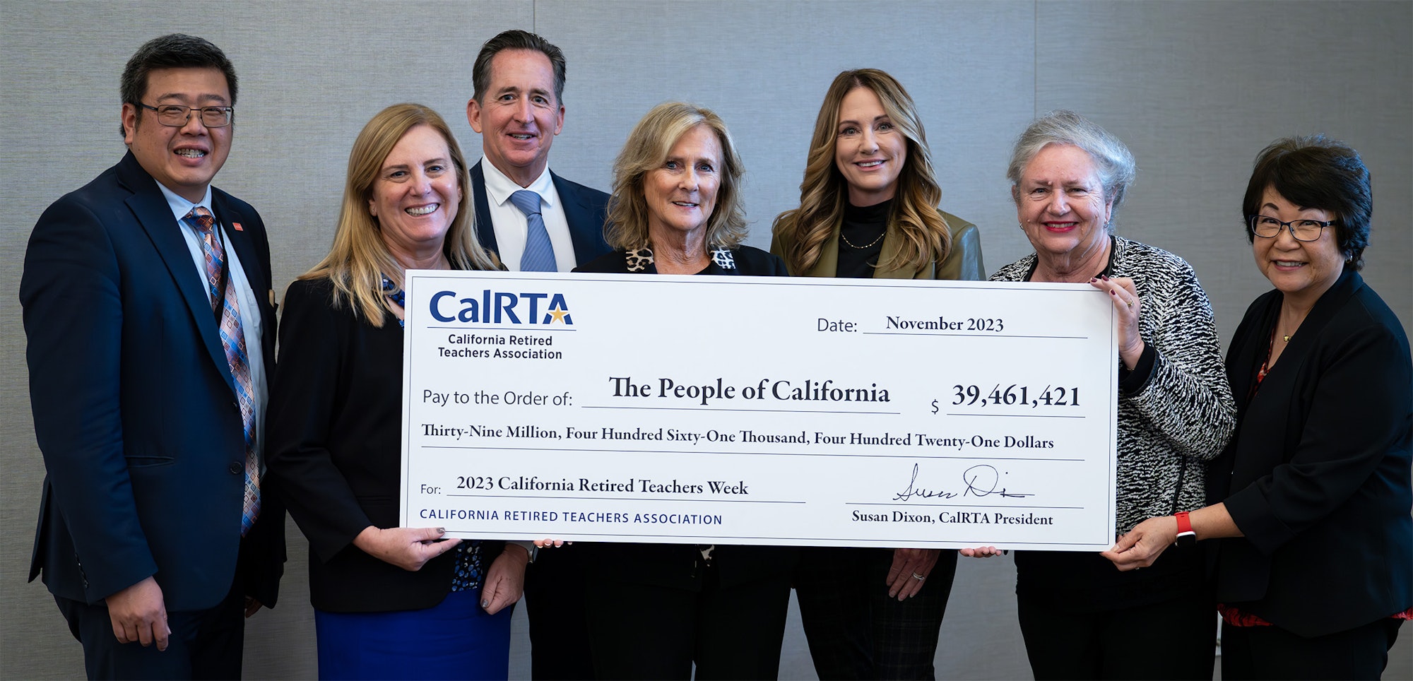 Group of people holding a large check written out to The People of California.