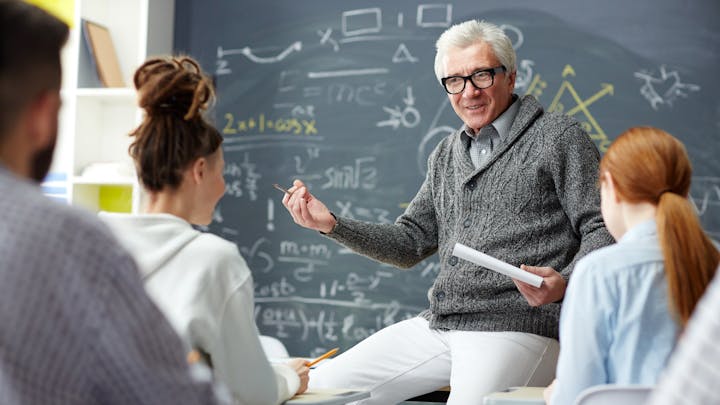 Teacher in front of students teaching class.