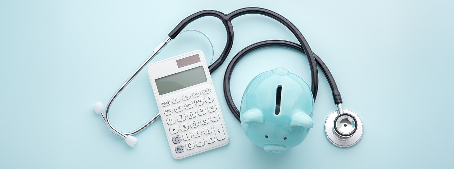 The image features a stethoscope, a calculator, and a teal piggy bank, symbolizing healthcare expenses and financial planning.