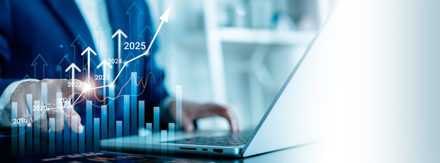A business person analyzes growth trends on a laptop, featuring rising graphs and projections for 2019 to 2025.