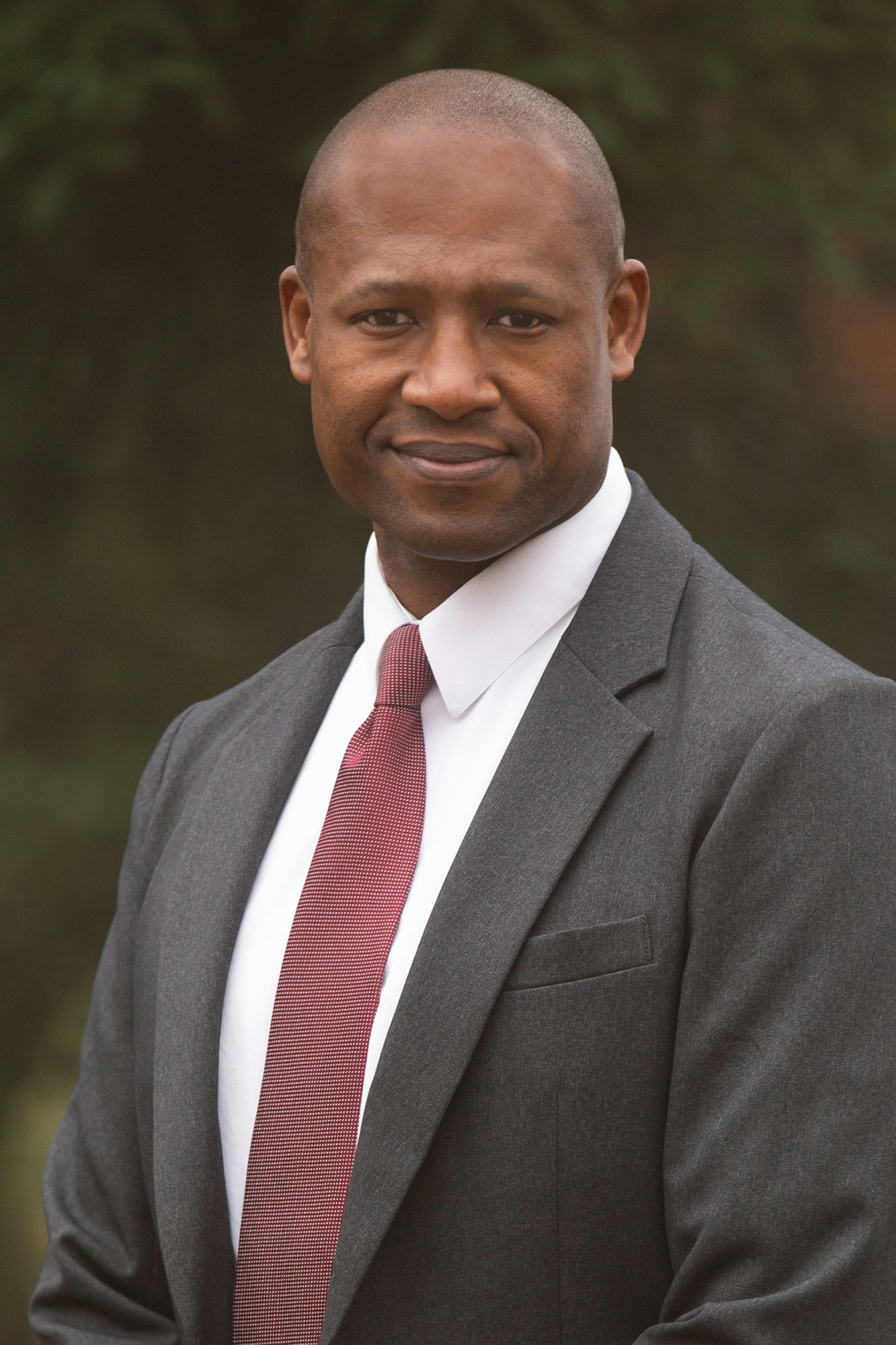Lamont King wears a gray blazer and red tie.