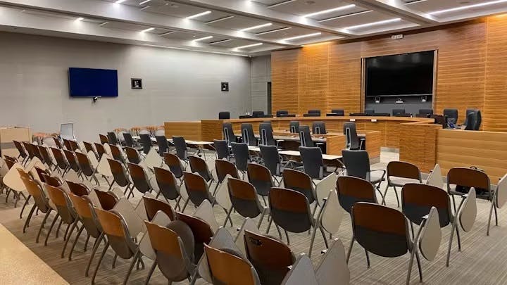 Modern conference room with chairs, a long table, and a large screen.