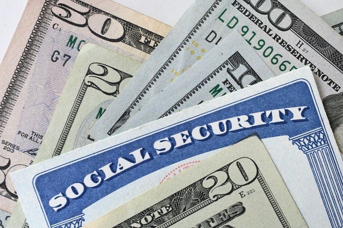 Social Security card and various denominations of U.S. dollar bills.