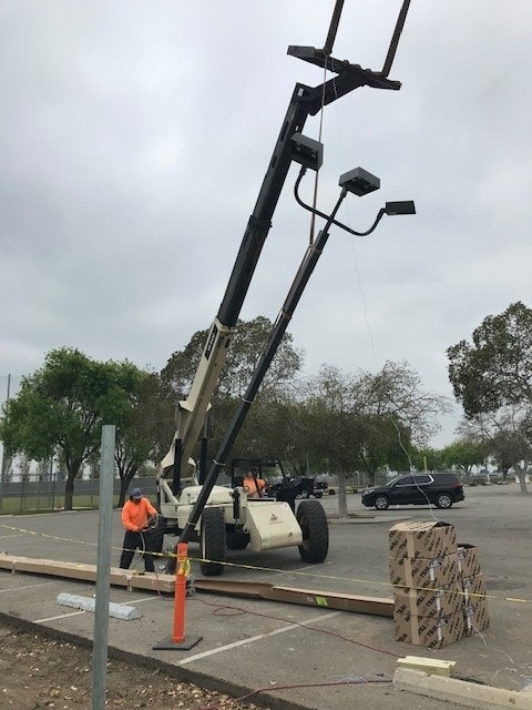 May contain: utility pole, person, car, transportation, vehicle, clothing, hat, and worker