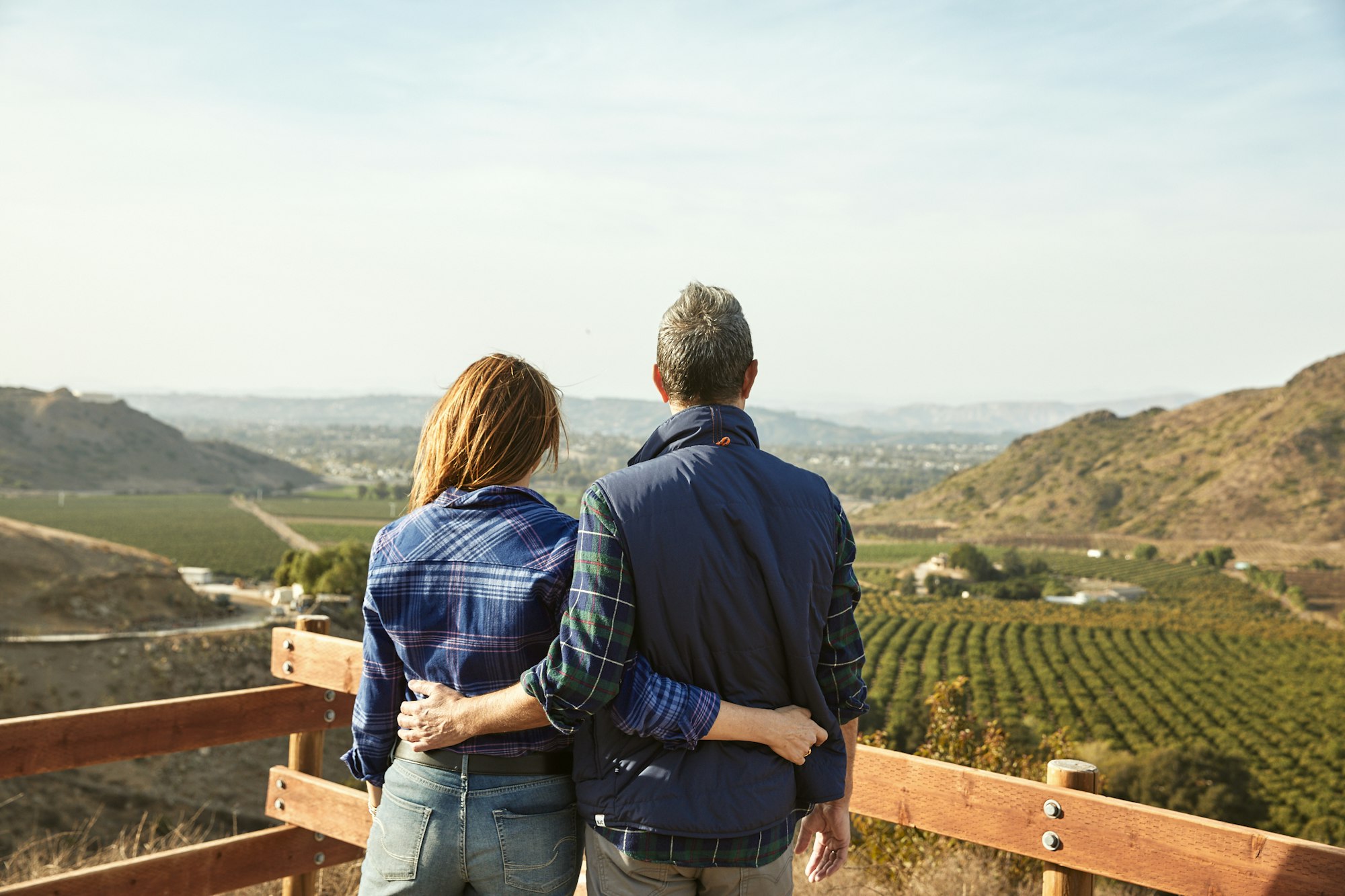 Two people overlooking a vineyard.