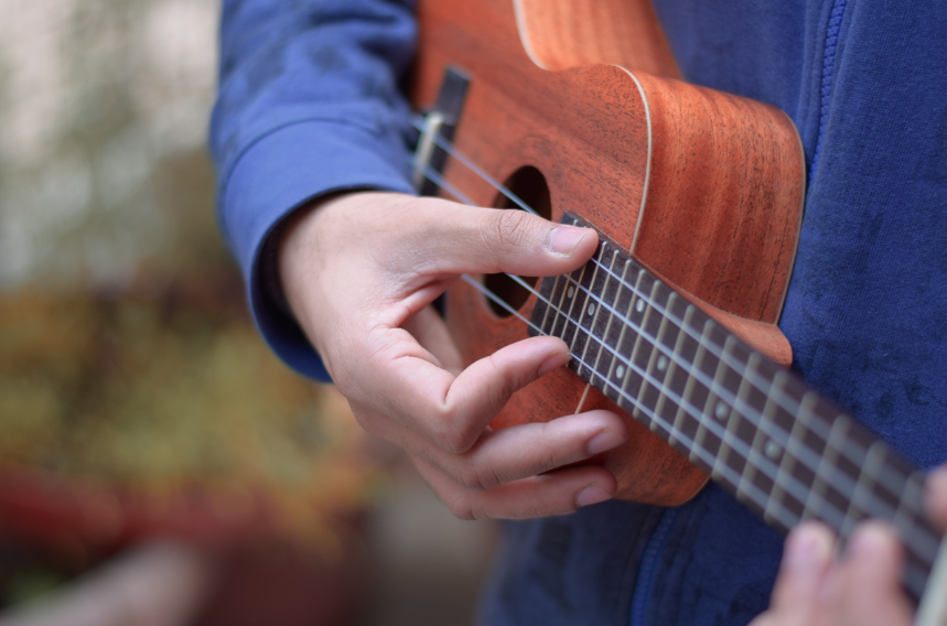 Close-up of hands playing a ukulele.