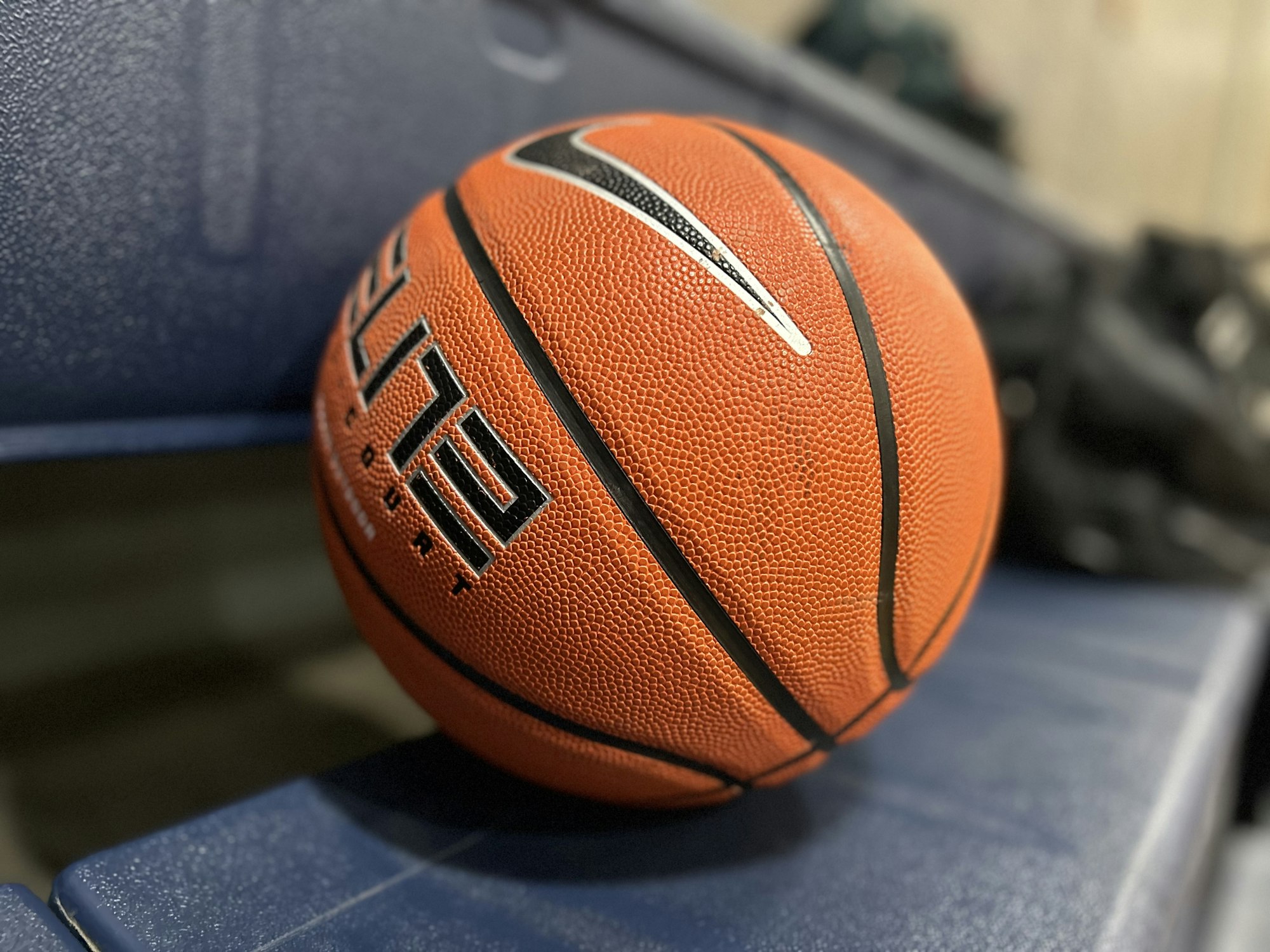 Close-up of a basketball on a blue seat with a blurred background.