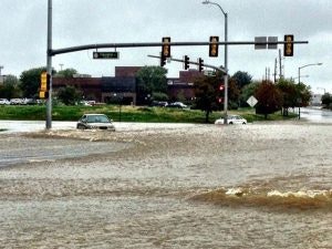 A flooded street with submerged cars and traffic lights.