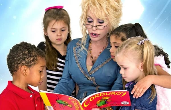A person reading "Corduroy" to a group of attentive children.