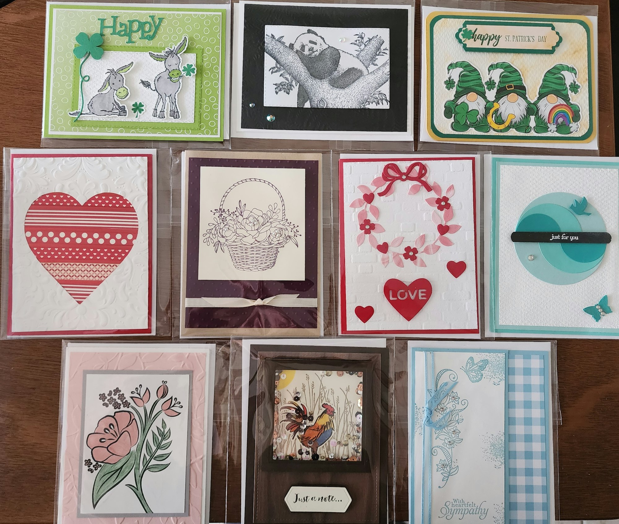 A collection of various handmade greeting cards featuring themes like love, sympathy, and celebration, with colorful designs.