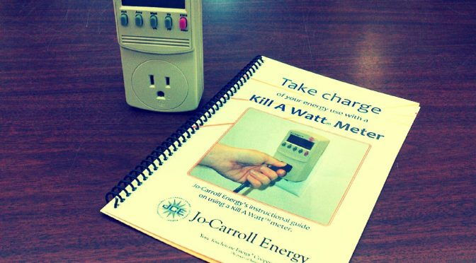 An outlet power meter and an instructional guide booklet on a table.