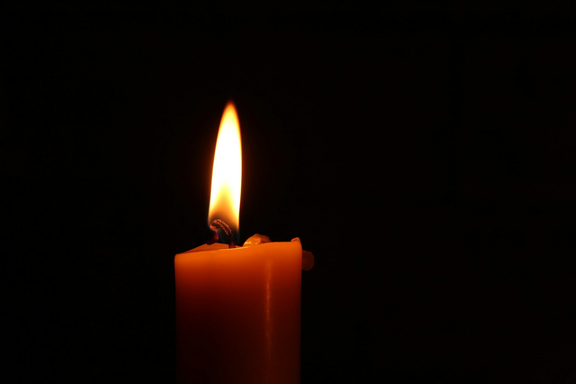 A lit candle in the dark.