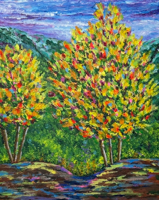 Colorful trees with vibrant foliage set against a lush green landscape and a blue, cloudy sky.