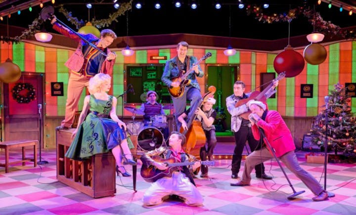 A vibrant stage performance with musicians, a singer on a piano, a band, retro outfits, and festive decorations.