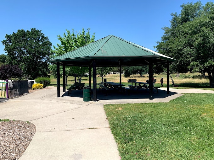 May contain: outdoors, architecture, building, shelter, bench, furniture, person, and gazebo