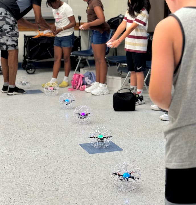 Students with drones in a classroom setting.