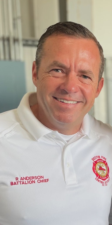 A person in a white polo with "R. Anderson Battalion Chief" and a fire department logo.