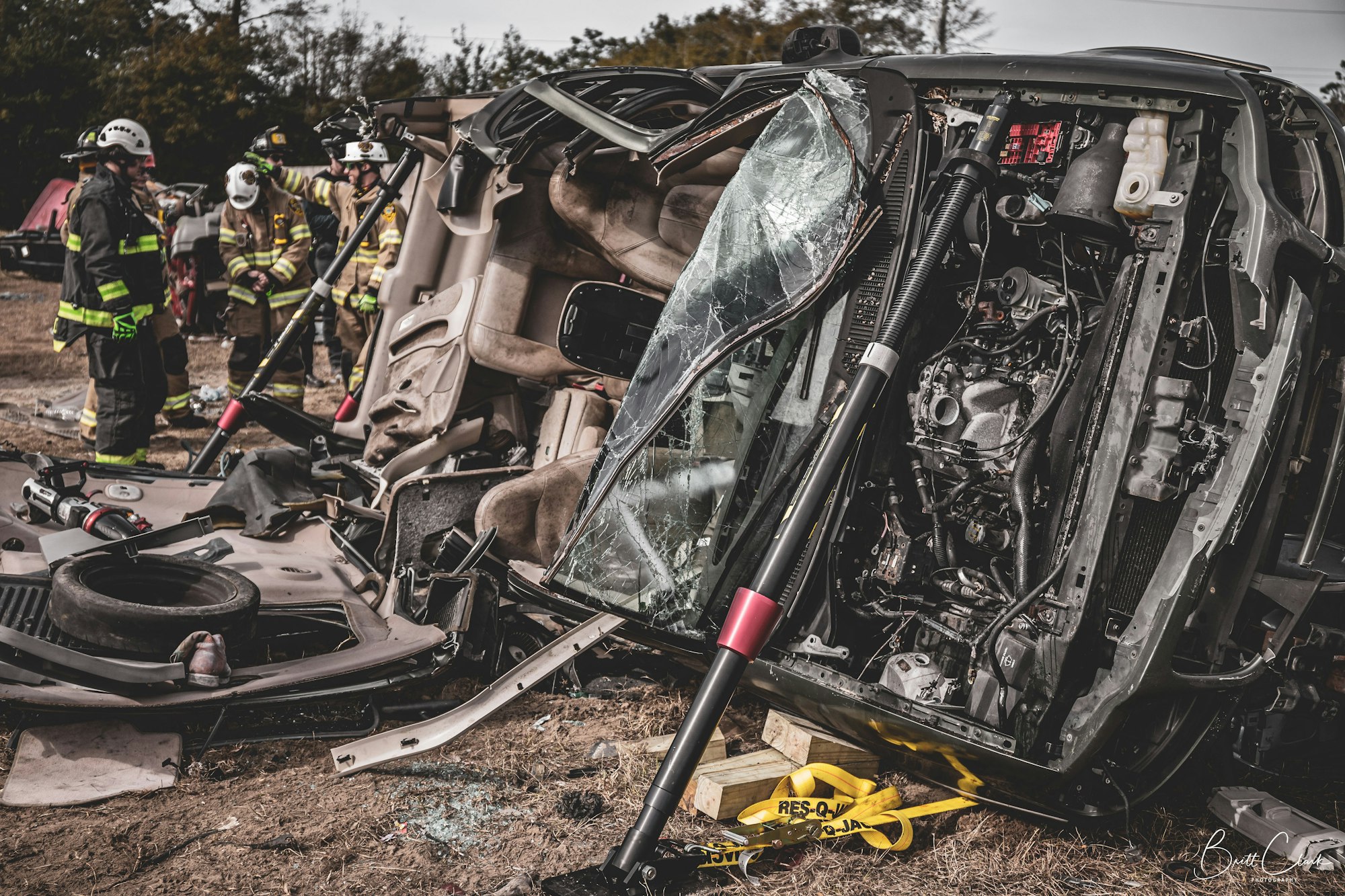 Firefighters at the scene of a vehicle accident with an overturned car.