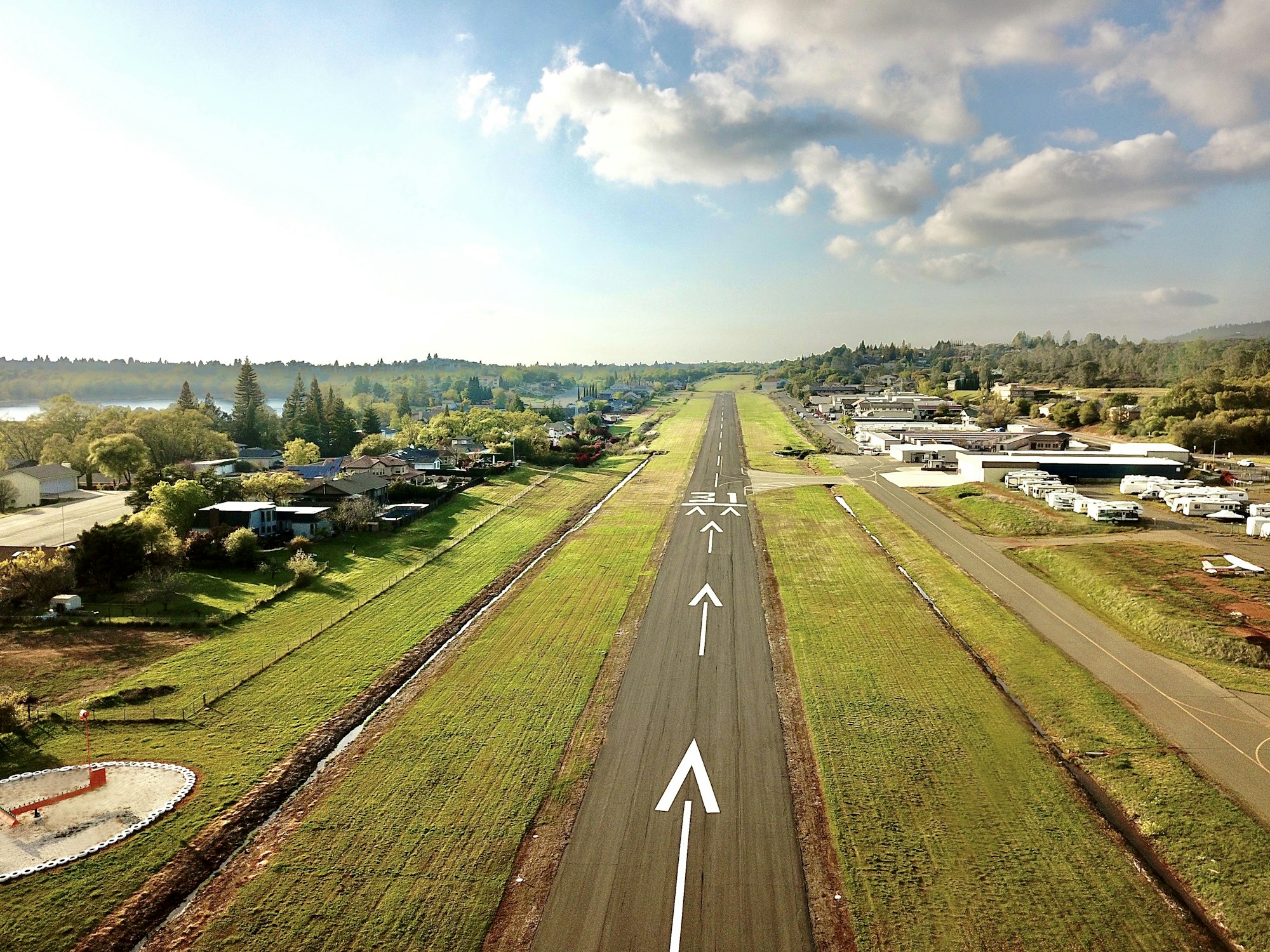 View of runway surrounded by lush grass on a sunny day