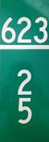 A green road sign with white numbers "623" above "25".