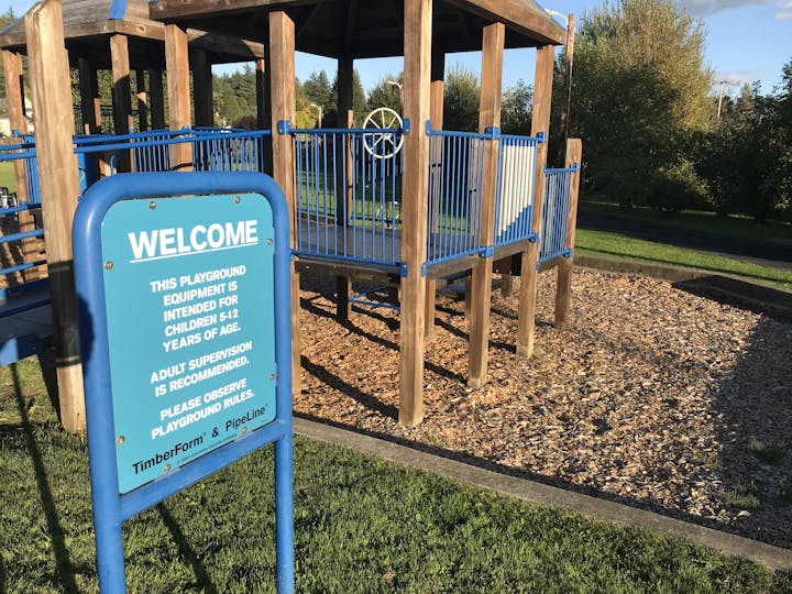 The image shows a playground for children aged 5-12, with a sign indicating rules and supervision recommendations.