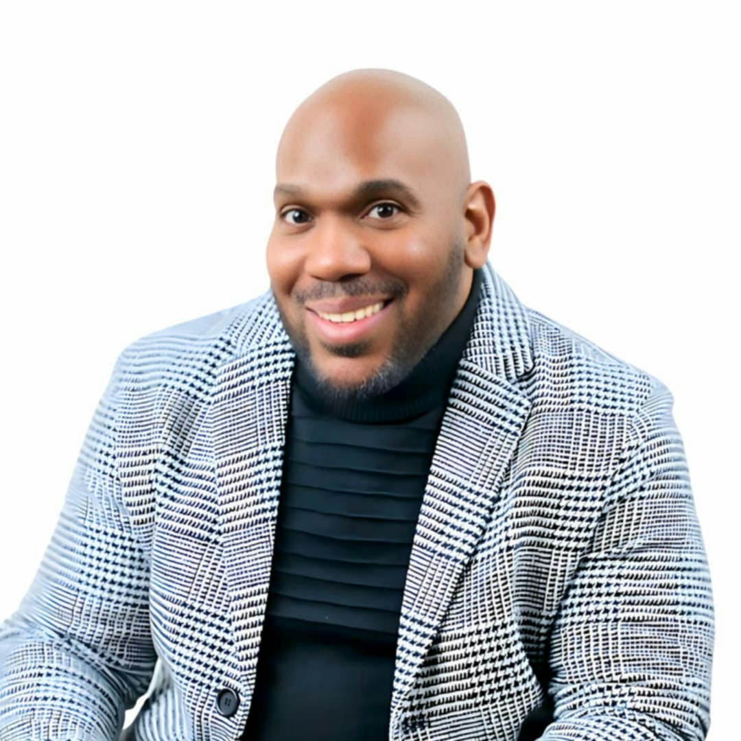 A smiling person in a checkered jacket on a white background.