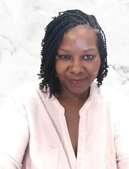 A woman with braided hair wearing a white shirt is smiling at the camera.