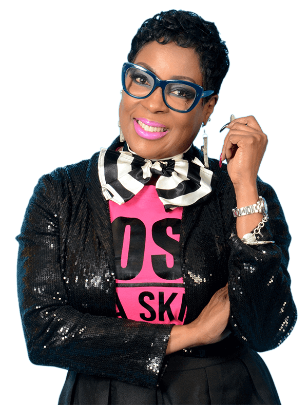 A woman in a black sequined jacket, pink shirt, and striped bow tie, wearing glasses and smiling.