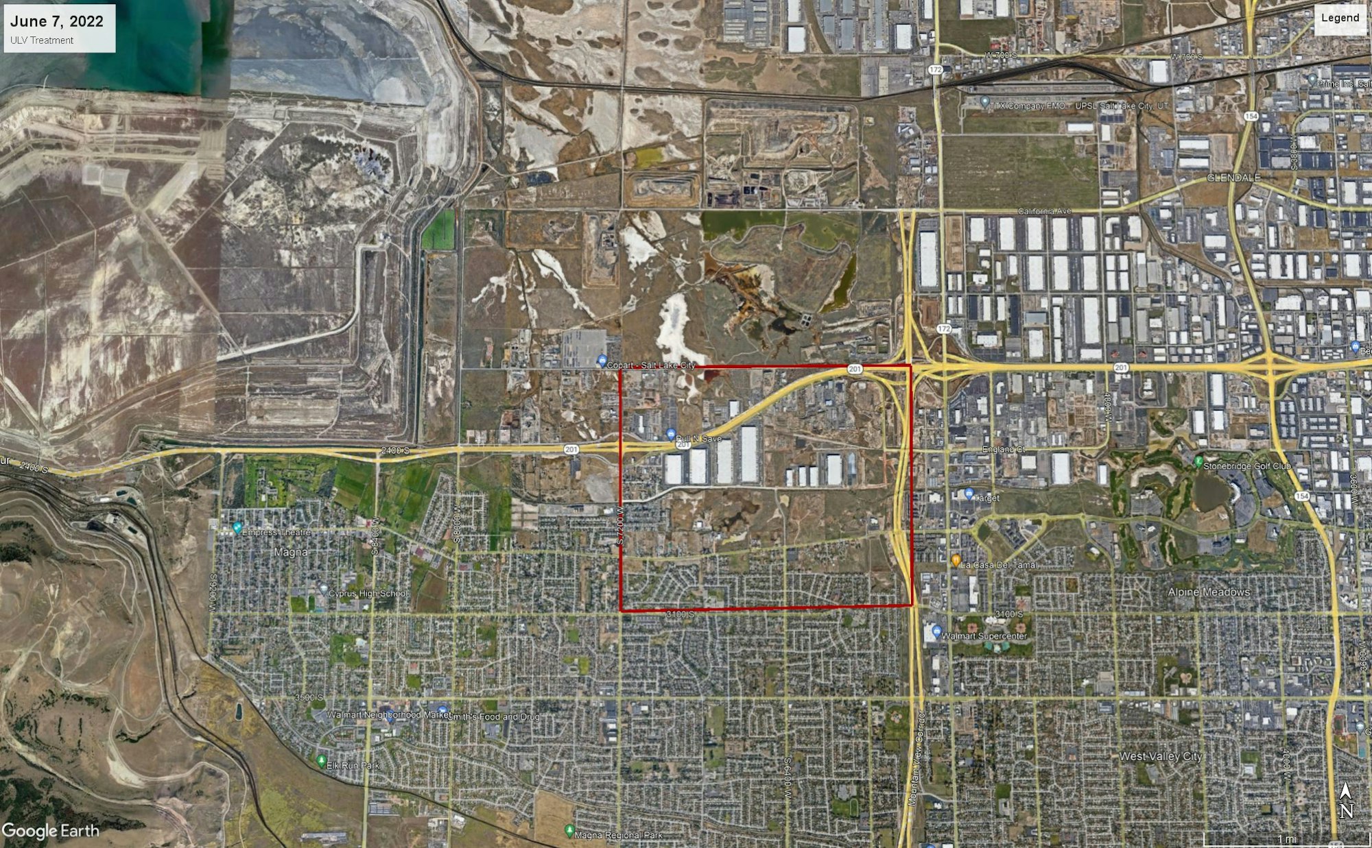 The image shows a satellite view of an industrial area with roads, buildings, and a delineated region highlighted in red.