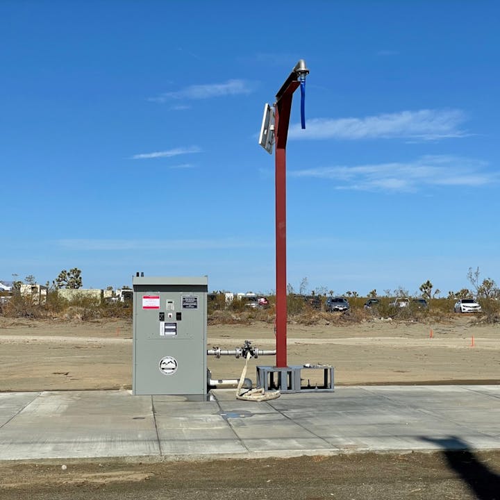 An outdoor electric vehicle (EV) charging station with infrastructure and blue sky.