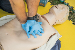 A person is performing CPR on a medical training mannequin.