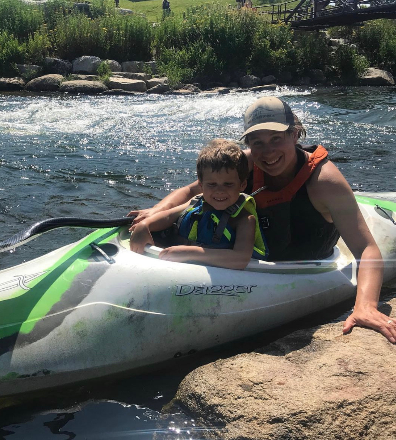 May contain: clothing, lifejacket, vest, face, head, person, photography, portrait, rock, summer, water, plant, vegetation, outdoors, boy, child, male, nature, lake, oars, and wilderness