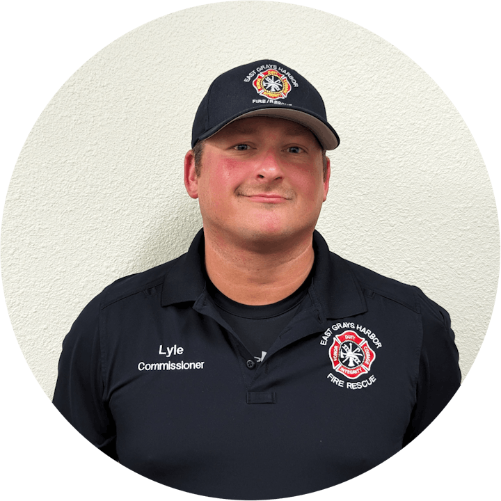 A man in a black shirt with "Commissioner" text, wearing a cap marked "Fire Rescue."