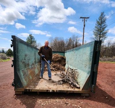 May contain: wood, soil, clothing, glove, pants, architecture, building, outdoors, shelter, adult, male, man, person, worker, and utility pole